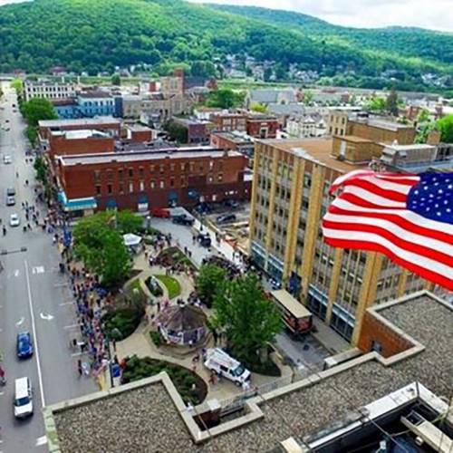 An american flag flies over a town square.